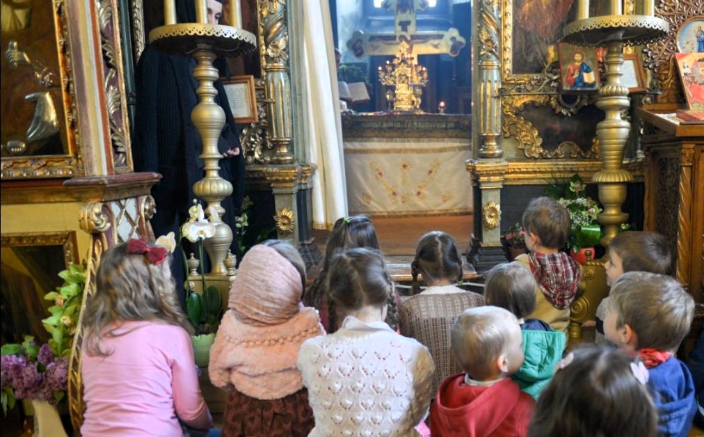 Copii la rugăciune în biserică. Sursa foto: Doxologia
