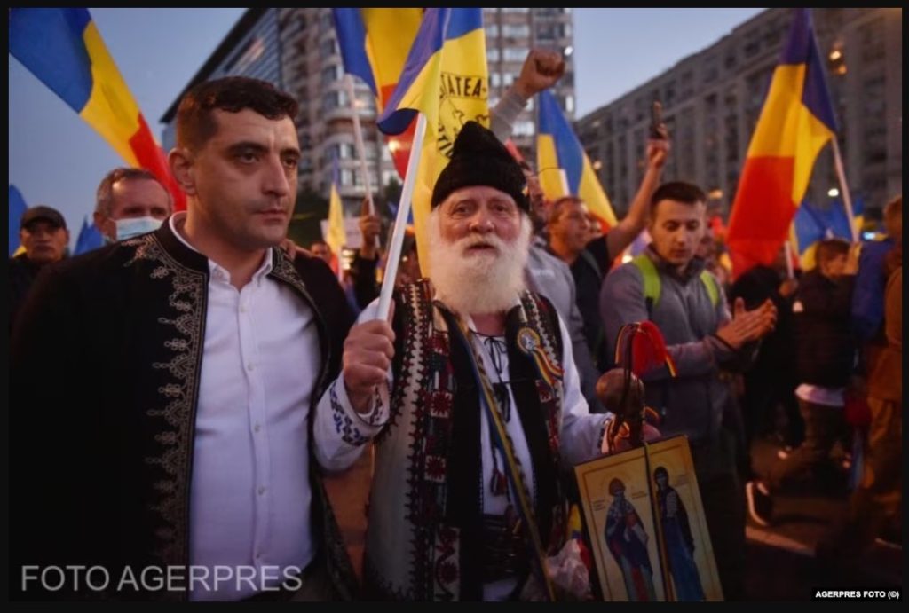 Din arsenalul propagandistic al AUR - îmbrăcămintea țărănească tradițională, steagul tricolor, icoana cu sfinți, bătrânul țăran înțelept / FOTO: AGERPRES