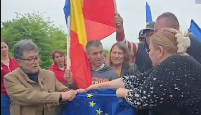 VIDEO. De Ziua Europei, Șoșoacă a rupt steagul UE la mănăstire, alături de fostul ziarist Miron Manega, actual senator SOS. Putinista e plătită cu 20.000 de euro ca europarlamentar. Partidul său a pus umărul, alături de PSD și AUR, la demiterea guvernului pro-european